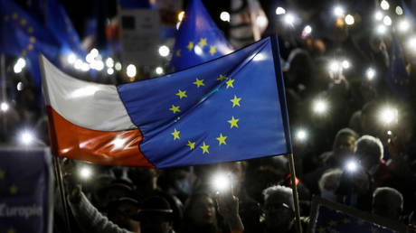 People hold flags and light up their mobile phones during a rally in support of Poland's membership in the European Union after the country's Constitutional Tribunal ruled on the primacy of the constitution over EU law in Warsaw, Poland, October 10, 2021. © Reuters / Kacper Pempel