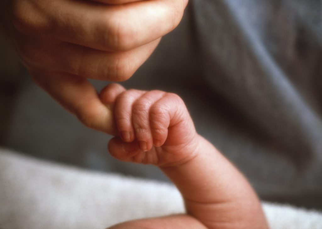 o femeie tine de mana un bebelus