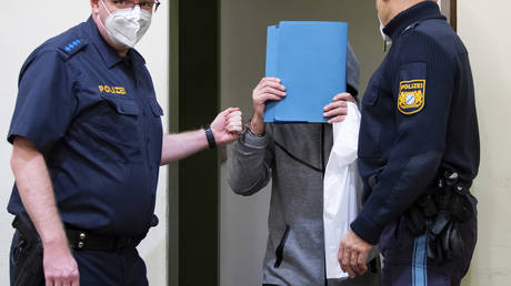 A man accused of murder by omission arrives in the courtroom before his trial begins in Munich, Germany, October 28, 2021