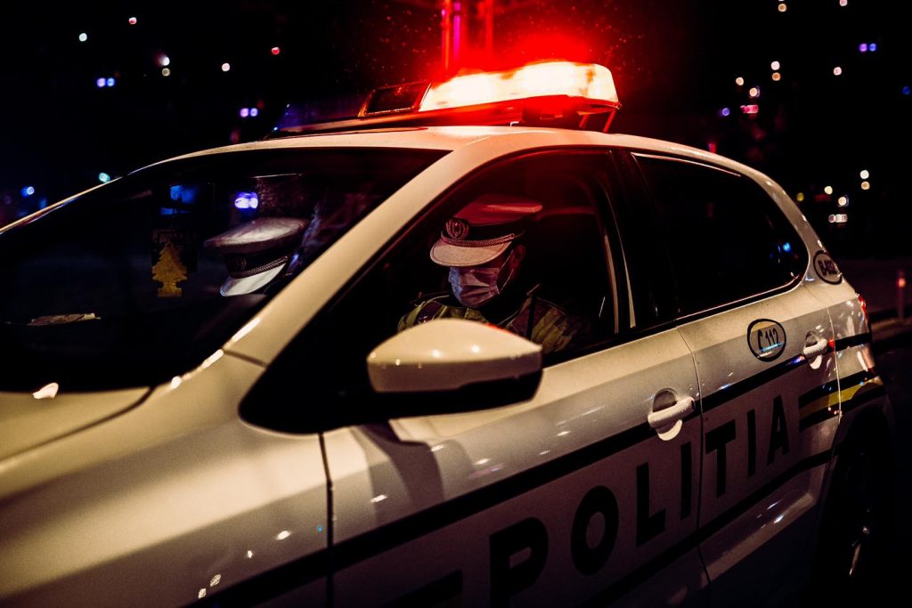 politisti intr-o masina de politie, noaptea.