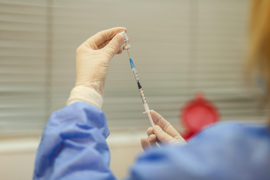o asistenta pregateste seringa pentru vaccinarea impotriva covid.