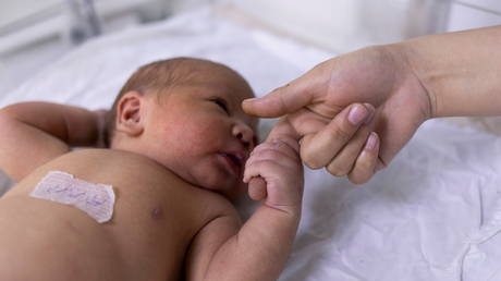 A newborn baby holds on a nurse's finger at the maternity ward in a children hospital. © Reuters / Jorge Silva