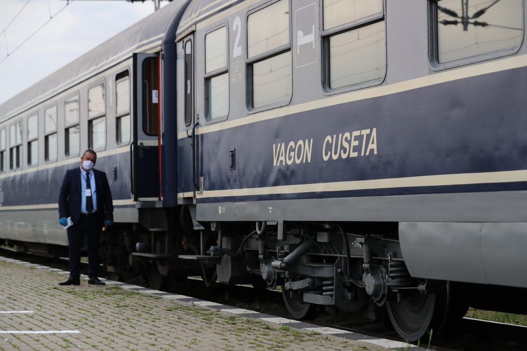 un controlor sta langa un tren de la cfr.