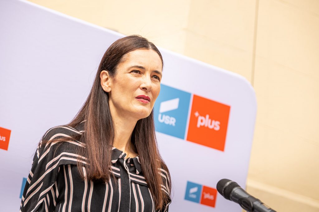 Clotilde Armand în fața unui panou USR PLUS.